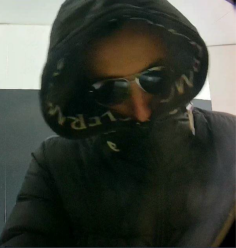 Man met zwarte capuchon op en zwarte zonnebril