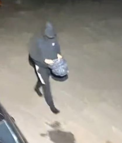 De verdachte loopt met iets brandbaars naar het pand