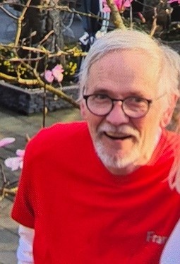 Man met bril en wit haar met een rood t-shirt.
