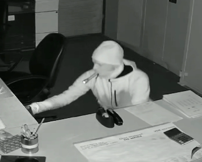 de verdachte doorzoekt het kantoor met een zaklamp in zijn mond