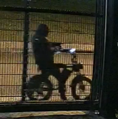 De verdachte op een fatbike bij het toegangshek.