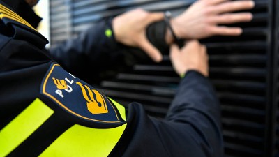 Een agent doet handboeien om bij een persoon