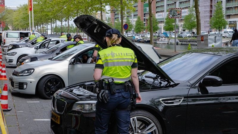 Politieagent controleert auto tijdens controle op de Verheeskade in Den Haag