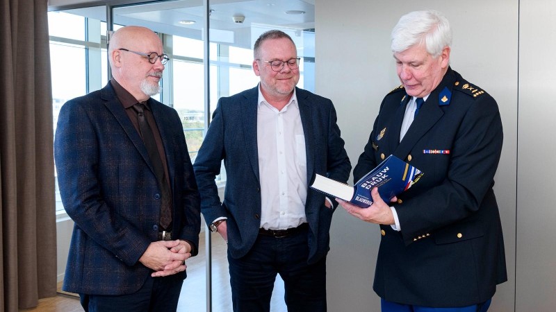Wim Bentvelzen (links) en Theo Postma reiken Blauwdruk uit aan korpschef Henk van Essen.