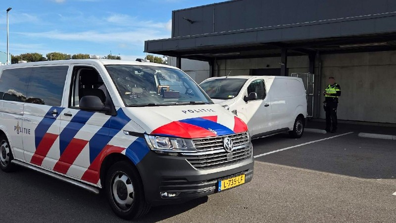 Politiebus op het terrein van een postpakketsorteerder