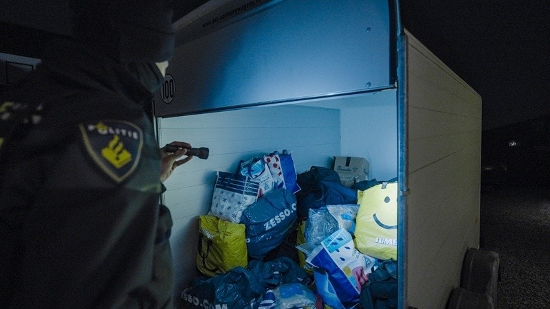 Agent kijkt naar aangetroffen big bags in trailer