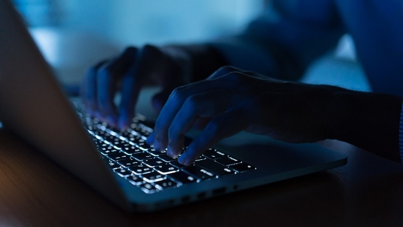 Laptop in het donker met verlichte toetsen