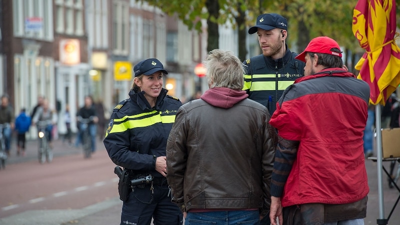 twee agenten in gesprek met twee personen