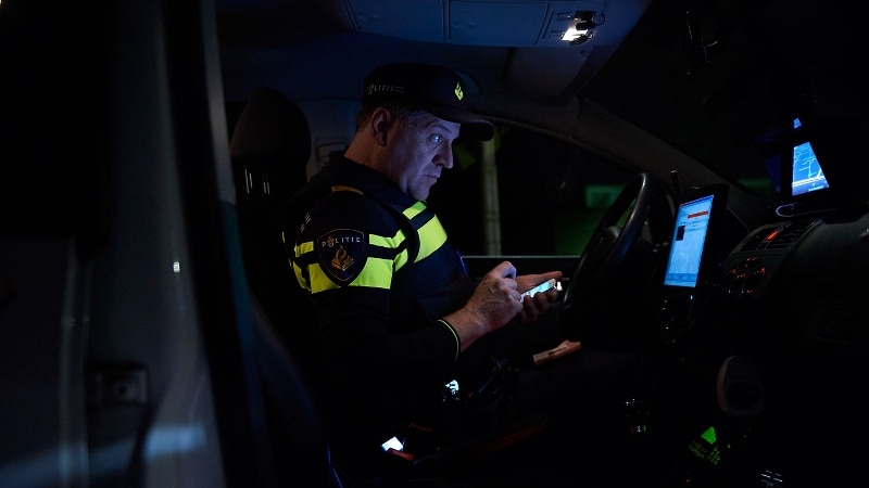 Agent controleert gegevens in dienstauto tijdens nachtdienst