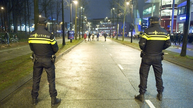 Twee agenten staan 's avonds op straat 'op wacht'
