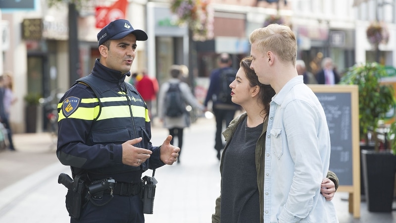 Agent praat met mensen op straat
