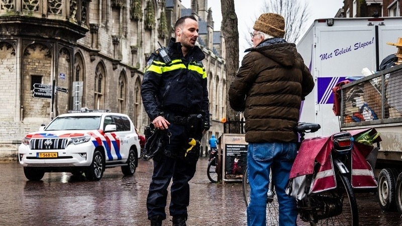 Agent in gesprek met oudere man met fiets