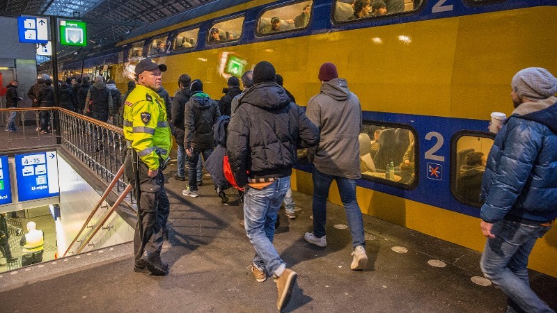 Agent controleert menigte bij intercity Amsterdam CS